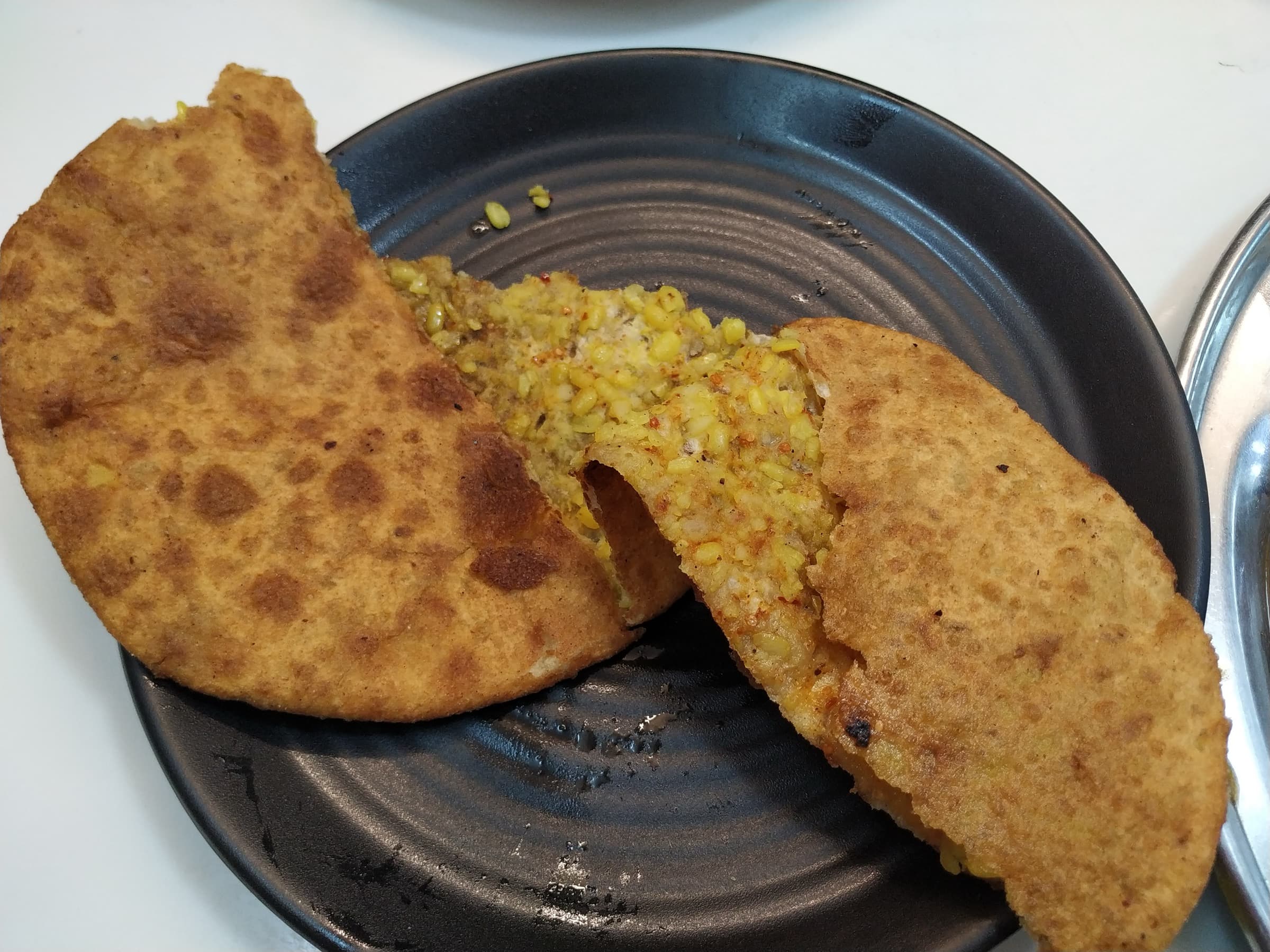 Dal parantha broken open on a plate at Paranthe Wali Gali, Chandni Chowk, Delhi