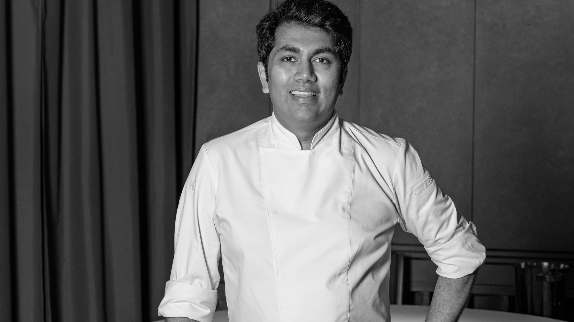 Chef Himanshu Saini in a white chef’s jacket, black-and-white portrait